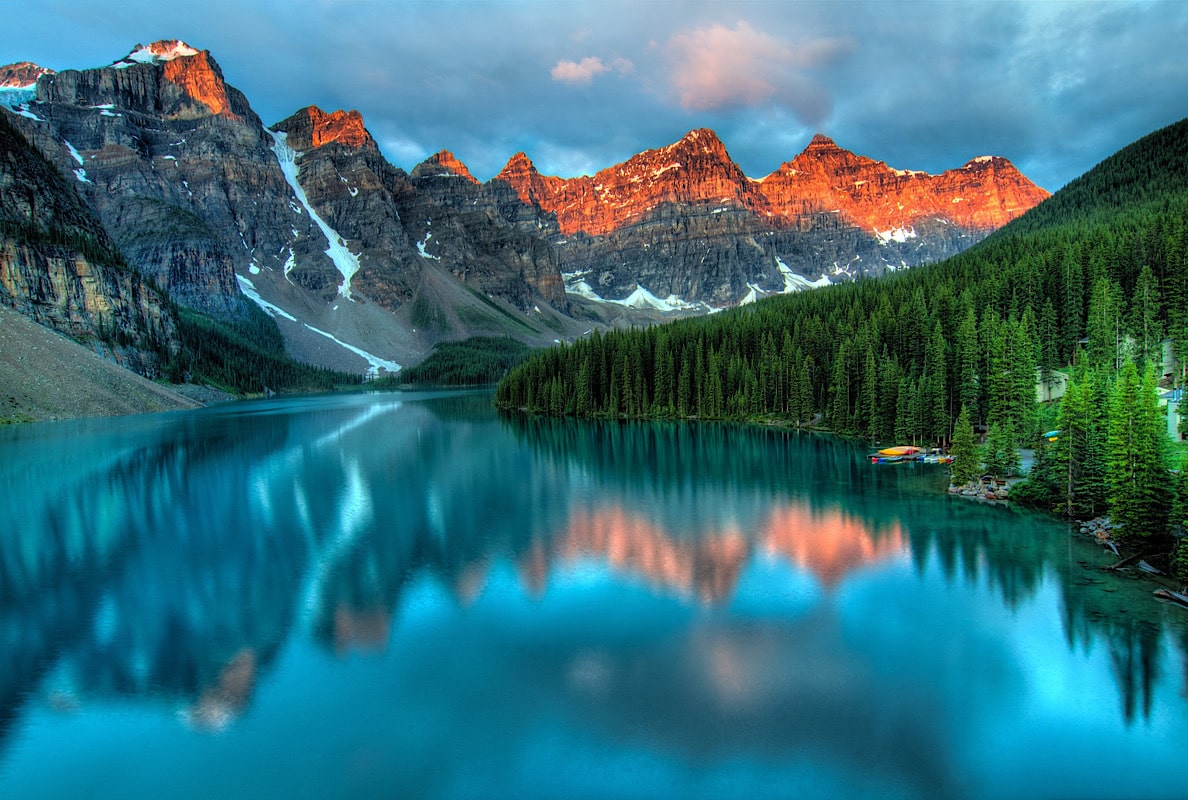 In einem stillen See spiegeln sich Berge und Wald.