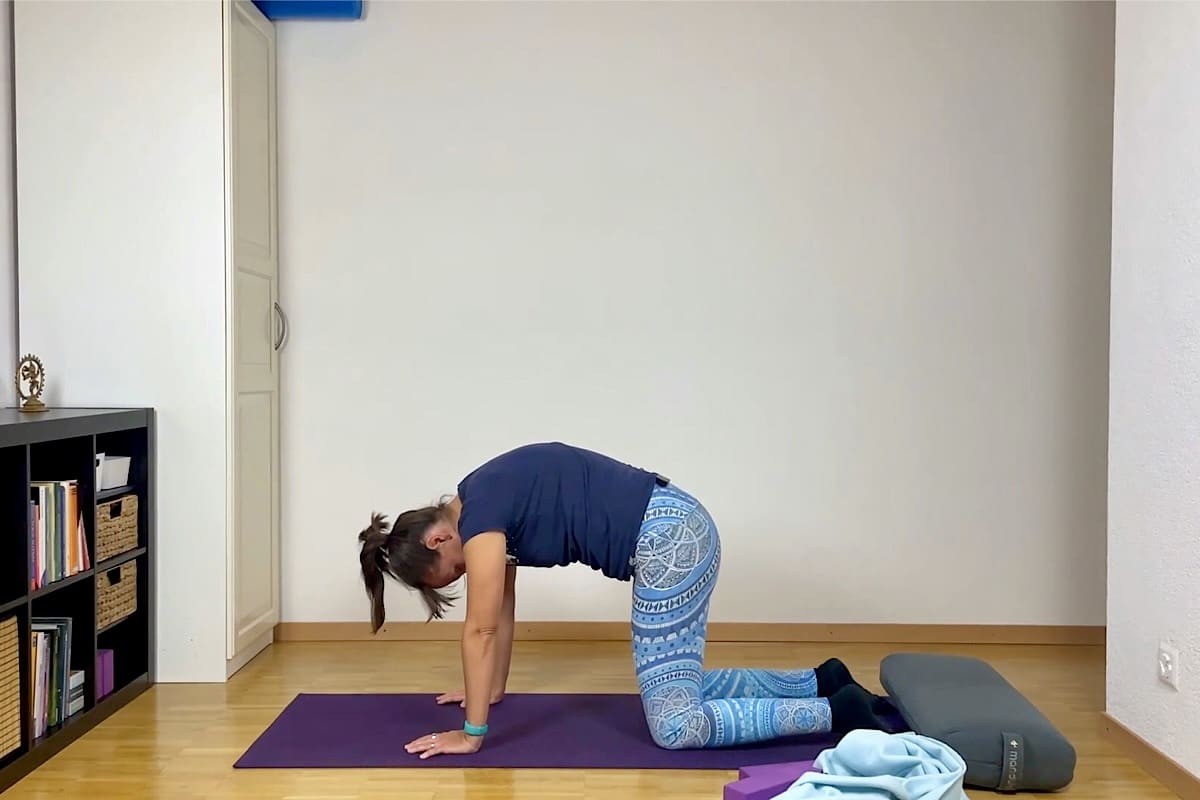 Frau im Vierfussstand mit Katzenbuckel.
